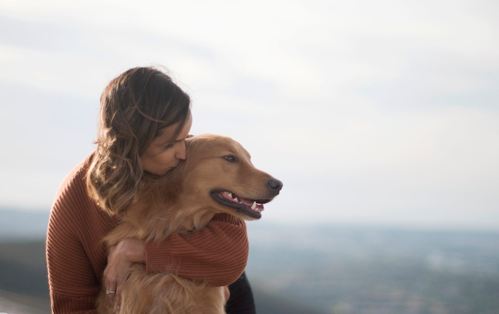 Woman cuddling golden retriever
